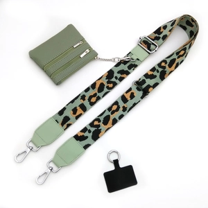 Detail eines verstellbaren Leopard-Taschenriemens mit passender grüner Geldbörse