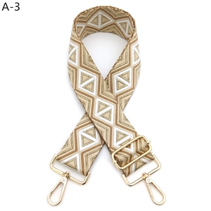 Detail of wide bohemian geometric strap with gold lobster clasps and metal buckle