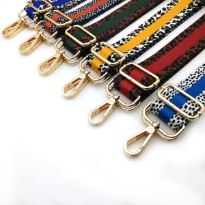 Detail view of colorful leopard print bag straps with shiny gold metal lobster clasps