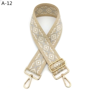 Detail of bohemian embroidered bag strap with beige geometric patterns and gold alloy buckles