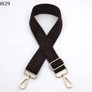 Detail of dark brown geometric pattern woven strap with adjustable gold buckles