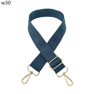 Close-up of dark blue bag strap with Greek Meander pattern and gold hardware hooks