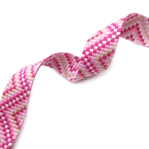 Close-up of pink and white checkered woven shoulder strap with a textured mosaic pattern