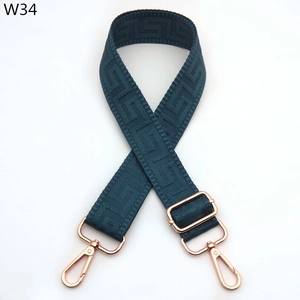 Macro shot of dark teal woven strap with geometric pattern and rose gold metal clasp