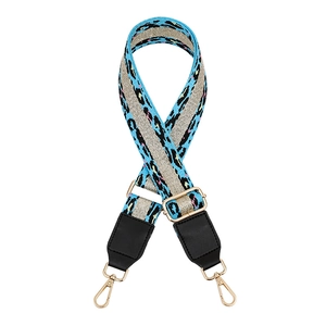 Detail of adjustable blue leopard print bag strap with gold metal buckles and black leather