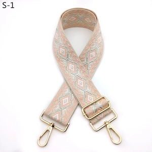 Detail of adjustable wide woven shoulder strap with pink geometric diamond embroidery and gold buckle