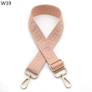 Detail of adjustable wide woven bag strap in pale pink with geometric greek key pattern