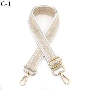 Detail of adjustable geometric embroidered bag strap with premium gold metal swivel hooks