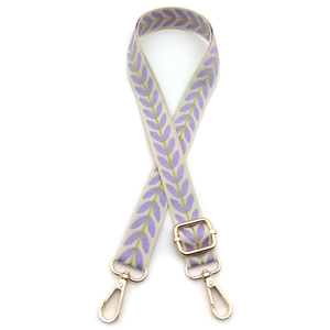 Close-up of adjustable cream strap with purple leaf embroidery and gold metal lobster clips
