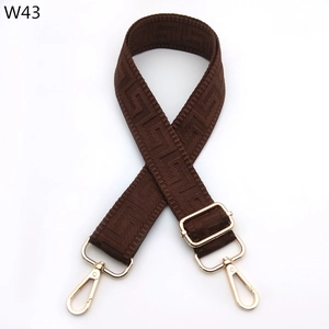 Close-up of brown geometric weave adjustable shoulder strap with gold metal buckles