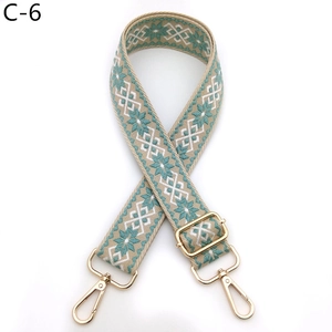 Close-up of ethnic jacquard shoulder strap with gold swivel hooks and blue floral patterns