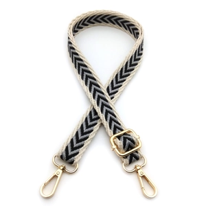Close-up of jacquard shoulder strap with black and white arrow pattern and gold hardware