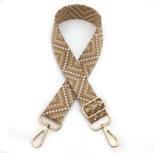 Detail of adjustable woven replacement shoulder strap with gold hardware and geometric pattern