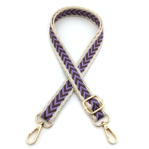 Detail of adjustable jacquard bag strap with purple geometric pattern and gold metal hooks