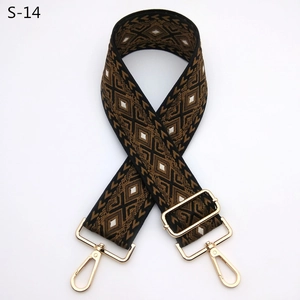 Detail of adjustable geometric patterned bag strap with gold metal rotating hooks