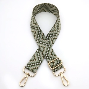 Detailed view of adjustable geometric woven strap with gold lobster clasps and buckles