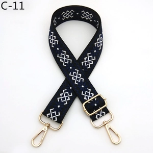 Close-up of adjustable bag strap with white geometric patterns and gold metal hooks