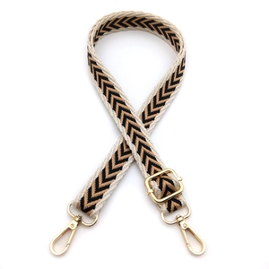 Detailed view of adjustable chevron pattern bag strap with gold metal swivel hooks