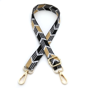 Detailed view of geometric arrow jacquard strap with polished gold-tone metal buckles