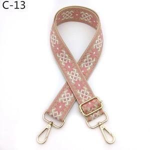 Detail of adjustable ethnic style pink geometric woven bag strap with gold metal hooks