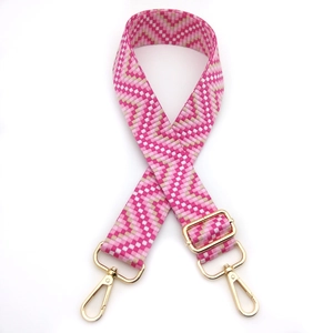 Detail of pink and white checkered woven strap with gold metal spring hooks and buckle