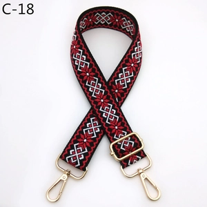 Detail of red and black geometric jacquard bag strap with golden metal lobster clasps