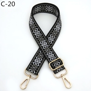 Detail of adjustable geometric jacquard bag strap with gold lobster clasps and hardware