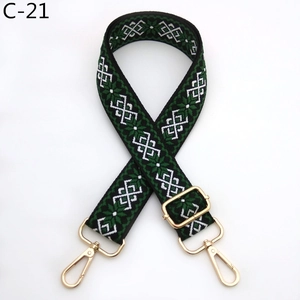 Close-up of geometric ethnic pattern bag strap with golden lobster hooks and buckle