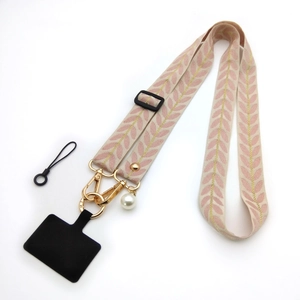Detail of embroidered vine phone strap with gold hardware and pearl charm