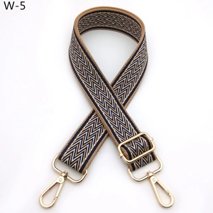 Close-up of zigzag woven adjustable shoulder strap with gold metal buckles and brown hues