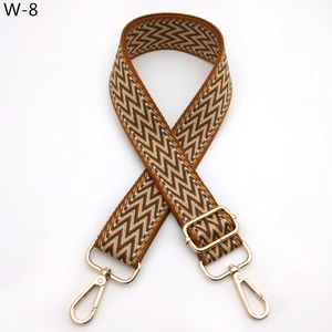 Detail of colorful woven shoulder strap with geometric patterns and gold metal buckles