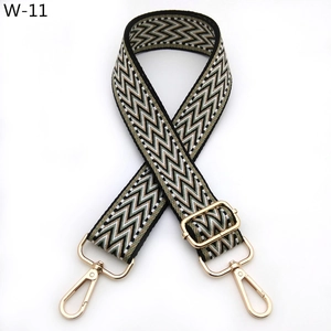 Detail of bohemian geometric pattern bag strap with golden metal swivel hooks and buckles