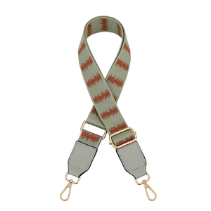 Detail of adjustable woven replacement bag strap with gold metal lobster clasps and grey PU leather