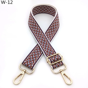 Close-up of ethnic woven bag strap with red and blue waves and golden metal hardware