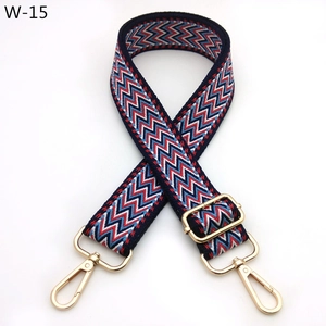Close-up of geometric woven strap with red blue zigzag patterns and gold metal hardware