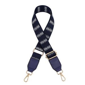 Detail view of navy blue gradient PU leather bag strap with wavy patterns and gold hooks