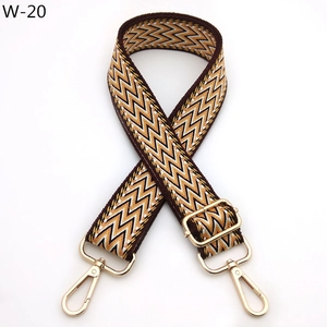 Close-up of bohemian brown and white woven purse strap with gold lobster clasps and buckles