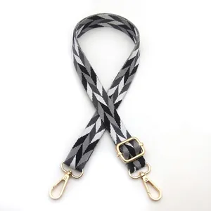 Detail of leaf pattern bag strap with gold metal buckle and swivel snap hook