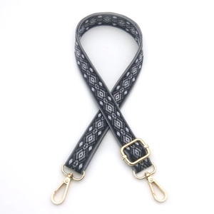 Close-up of geometric diamond pattern shoulder strap with gold metal lobster clasps