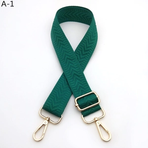 Detail of dark green woven strap with herringbone texture and gold metal hooks