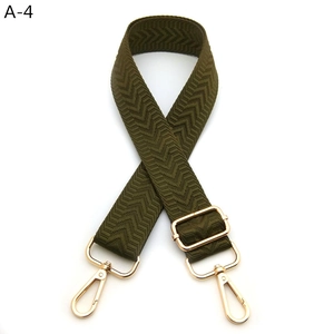 Detail of army green woven shoulder strap with gold metal buckle and V-pattern jacquard