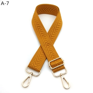 Detail of yellow herringbone strap with golden lobster clasp and slide adjuster