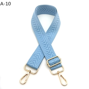 Close-up of baby blue chevron woven bag strap with gold-tone metal adjustable buckle