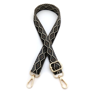 Macro detail of adjustable woven bag strap with retro diamond pattern and gold metal hooks