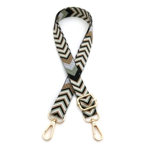 Close-up of adjustable woven purse strap with retro geometric chevron pattern and gold metal hooks