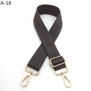 Detail of adjustable dark brown herringbone strap with golden metal swivel hooks