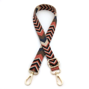 Close-up of adjustable ethnic style wide bag strap with arrow pattern and gold metal hooks