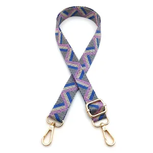 Detail view of colorful geometric woven bag strap with adjustable gold lobster clasps