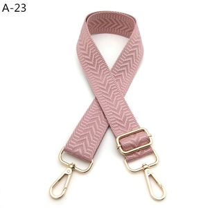 Close-up of pink-purple woven strap with herringbone texture and gold metal hardware