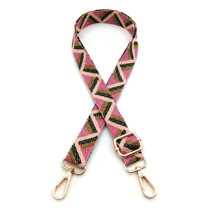 Detail of adjustable geometric pink and green woven shoulder strap with gold metal clasp